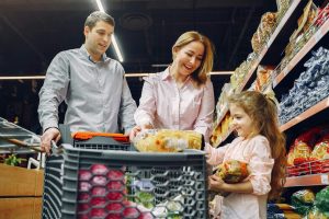 The image shows a couple shopping in a grocery store with their daughter