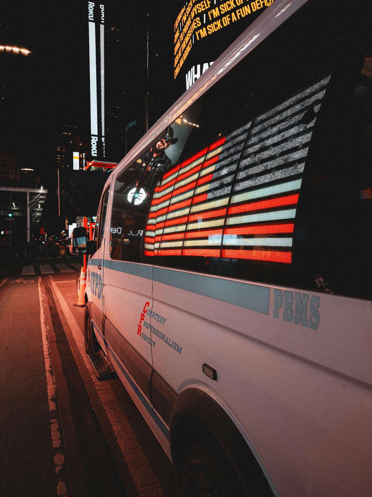 The image shows the american flag being reflected on a police car