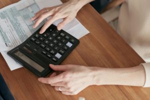 Image shows hands typing on a calculator